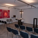 Blick in die Altenheimkapelle mit Tabernakel, Altar, einem Kreuz mit Corpus sowie dem Ambo (© Herr Mag. Bernhard Wagner).
